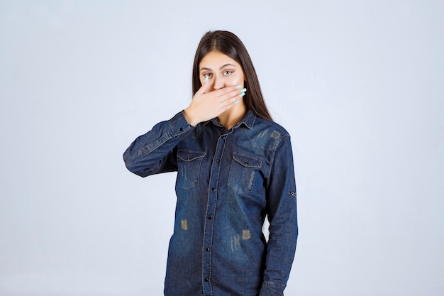 Mujer joven tapándose la boca y guarda silencio