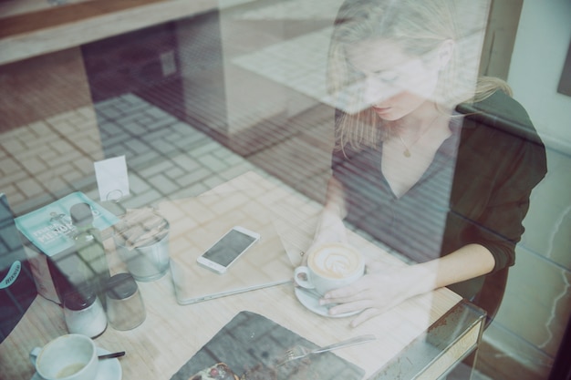 Mujer joven con una taza de café en la cafetería