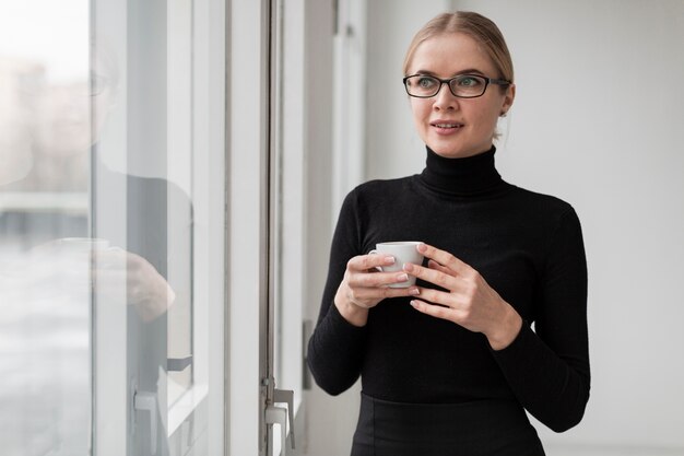 Foto gratuita mujer joven con taza de café