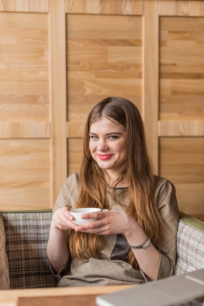 Foto gratuita mujer joven con una taza sonriendo