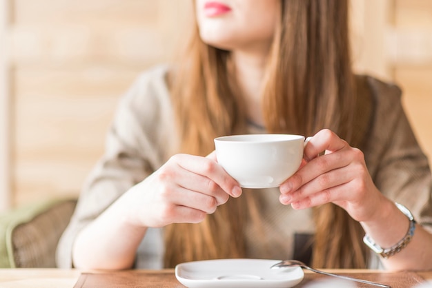 Mujer joven con una taza de té entre sus manos