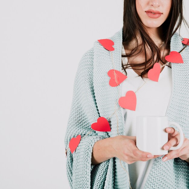 Mujer joven con taza en tela escocesa