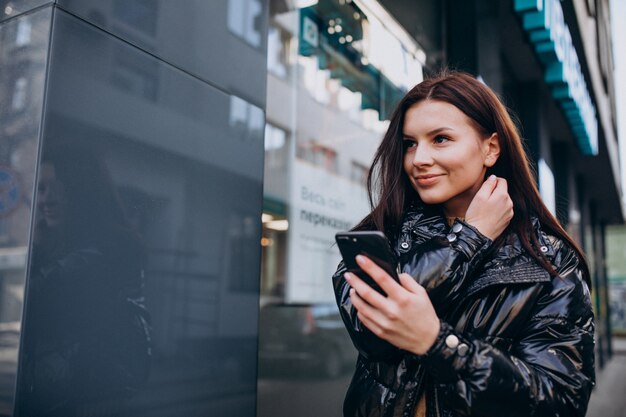 Mujer joven con teléfono al aire libre