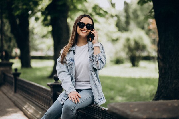 Mujer joven con teléfono fuera de la ciudad