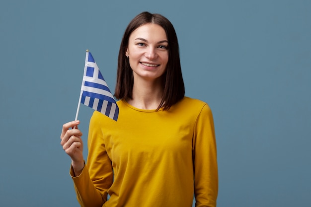 Foto gratuita mujer joven, tenencia, bandera de grecia