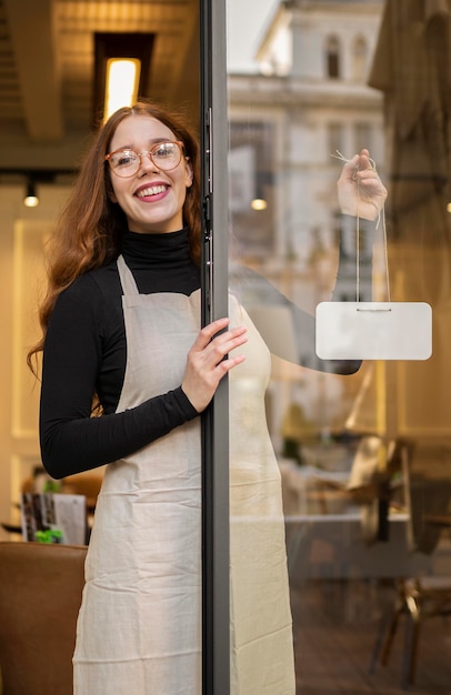 Foto gratuita mujer joven, tenencia, cartel de la tienda