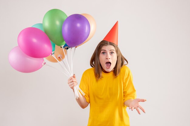 mujer joven, tenencia, colorido, globos, blanco