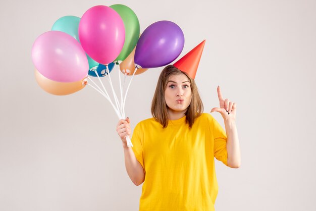 mujer joven, tenencia, colorido, globos, blanco