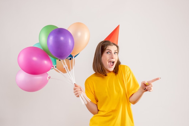 mujer joven, tenencia, colorido, globos, blanco