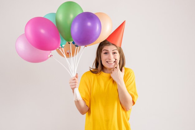 mujer joven, tenencia, colorido, globos, blanco