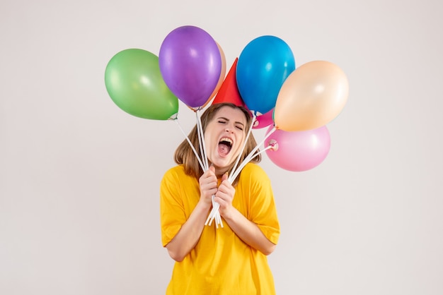 mujer joven, tenencia, colorido, globos, blanco