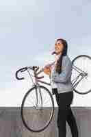Foto gratuita mujer joven, tenencia, ella, bicicleta
