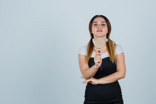 Mujer joven, tenencia, lupa