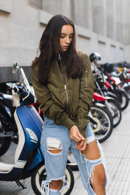 Mujer joven tirando de las mangas de la chaqueta.