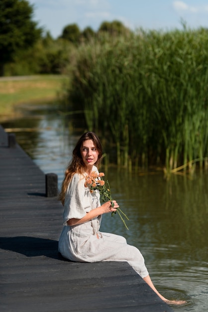 Foto gratuita mujer joven de tiro completo con flores