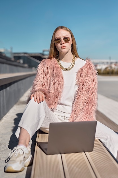 Foto gratuita mujer joven de tiro completo con laptop al aire libre