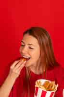 Foto gratuita mujer joven de tiro medio comiendo comida rápida