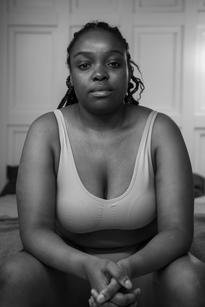 Mujer joven de tiro medio posando en blanco y negro