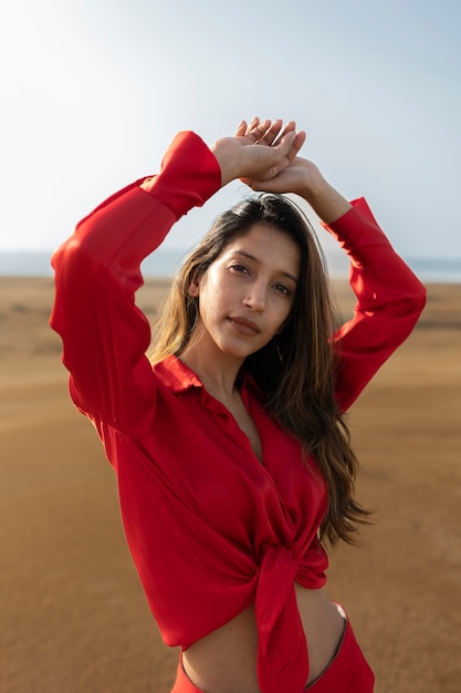 Mujer joven de tiro medio posando en el desierto