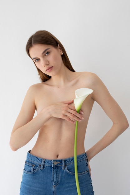 Mujer joven de tiro medio posando con flor