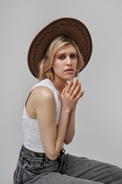 Mujer joven de tiro medio posando con sombrero