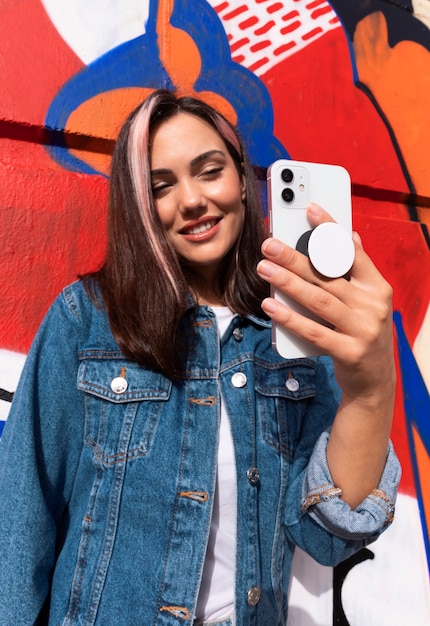 Foto gratuita mujer joven de tiro medio usando popsocket