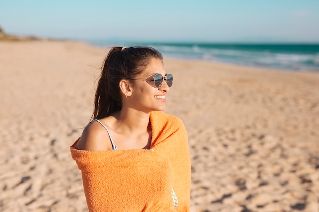 Mujer joven, con, toalla, en, playa arenosa