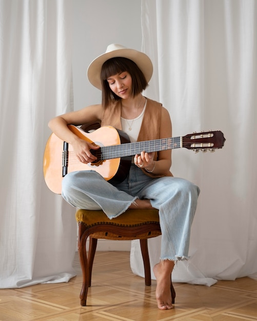 Mujer joven, tocar la guitarra, adentro