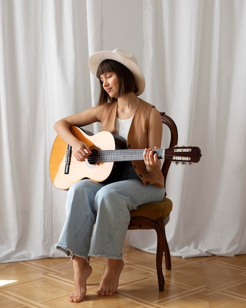 Mujer joven, tocar la guitarra, adentro