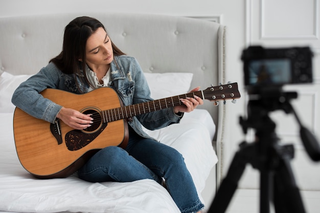 Mujer joven, tocar la guitarra