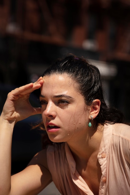 Foto gratuita mujer joven tolerando la ola de calor al aire libre