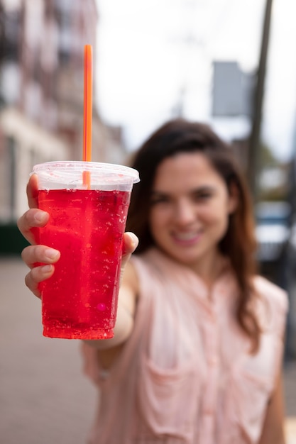 Mujer joven tolerando la ola de calor con una bebida fría