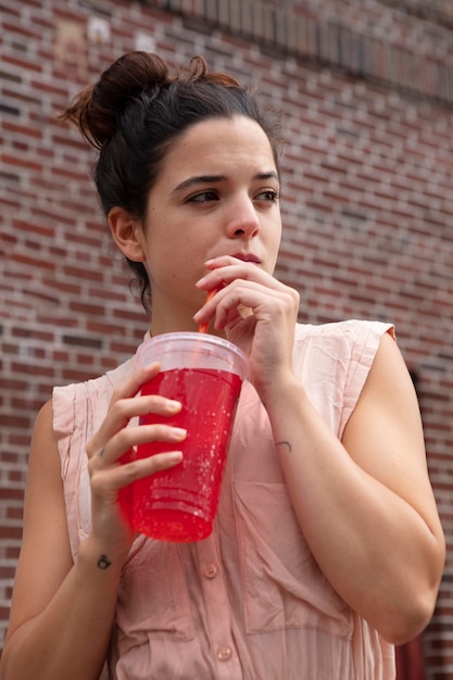 Mujer joven tolerando la ola de calor con una bebida fría