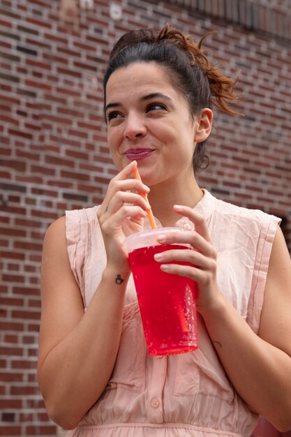 Mujer joven tolerando la ola de calor con una bebida fría