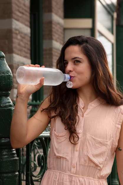 Mujer joven tolerando la ola de calor con una bebida fría