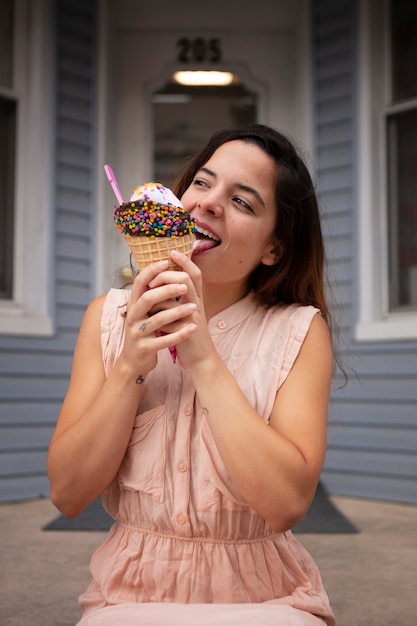 Foto gratuita mujer joven tolerando la ola de calor mientras come un helado