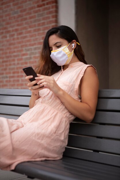 Mujer joven tolerando la ola de calor mientras usa una máscara médica