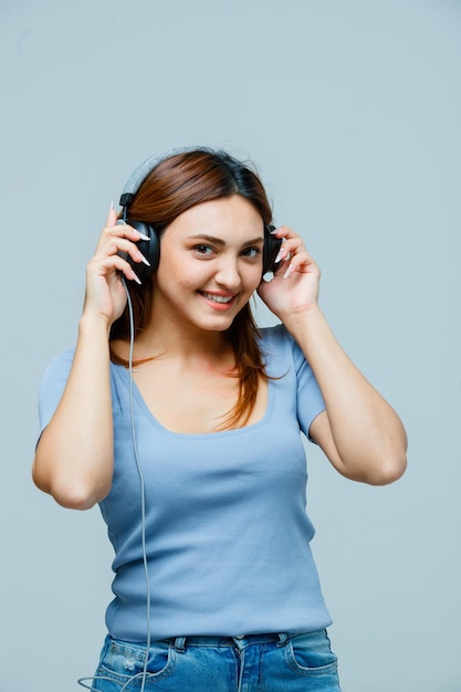 Mujer joven tomados de la mano en los auriculares mientras escucha música