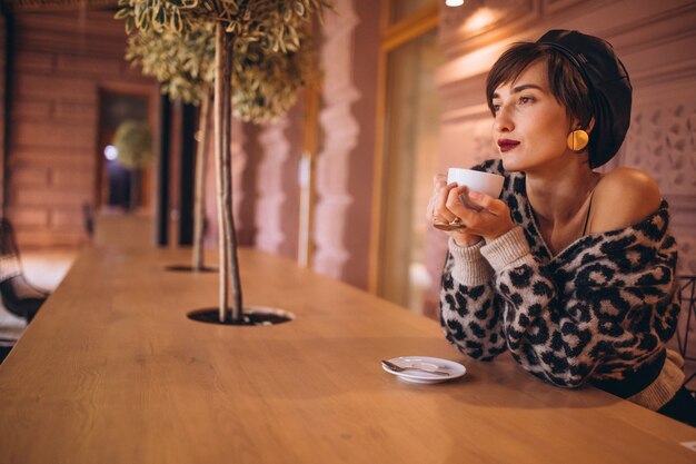 Mujer joven tomando café en un café