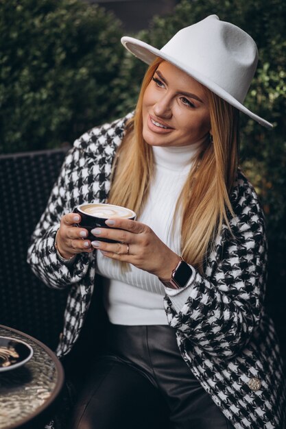 Mujer joven tomando café en un café
