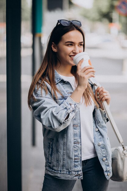 Mujer joven tomando café en la ciudad