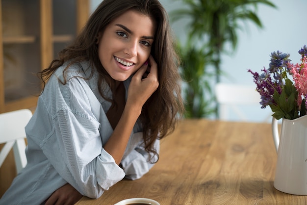 Mujer joven tomando café en el comedor