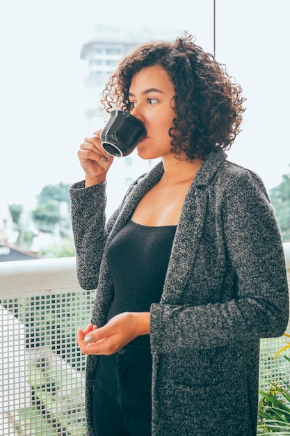 Foto gratuita mujer joven tomando café