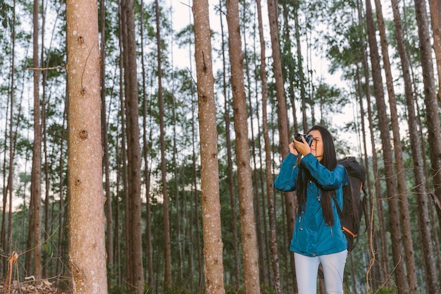 Mujer joven tomando foto con cámara