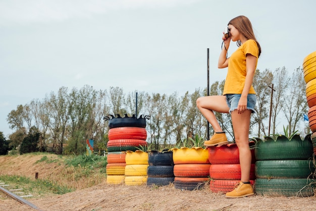 Mujer joven tomando una foto en el campo