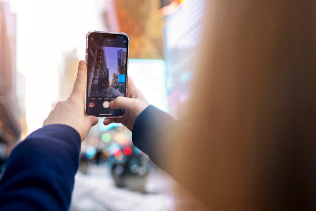 Mujer joven tomando una foto de la ciudad de nueva york durante el día