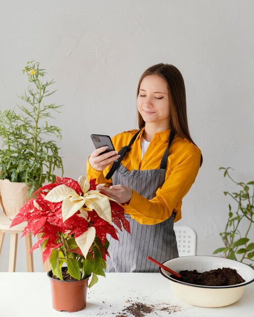 Mujer joven tomando una foto de su planta