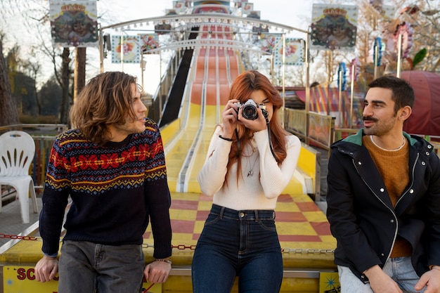 Mujer joven tomando fotos cerca de sus amigos