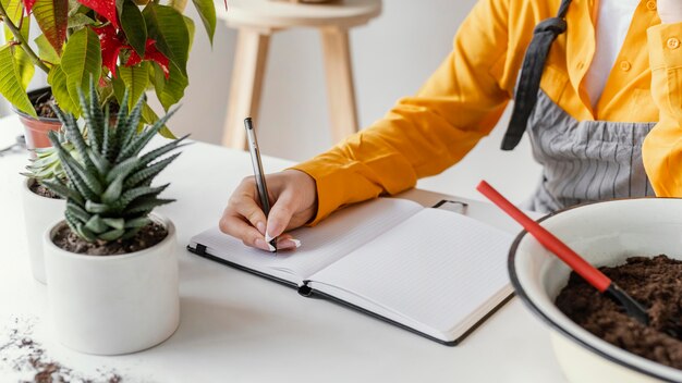 Mujer joven tomando notas de jardinería