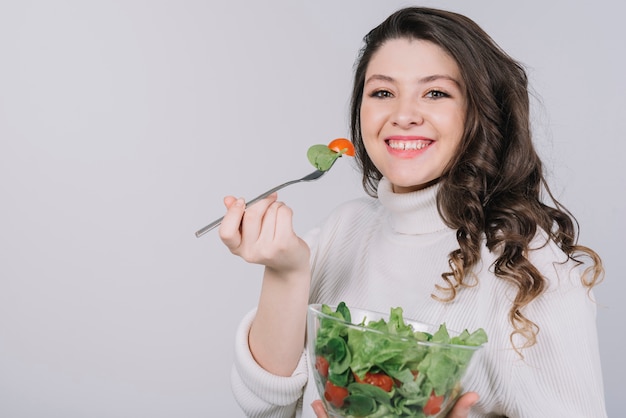 Mujer joven tomando un plato saludable